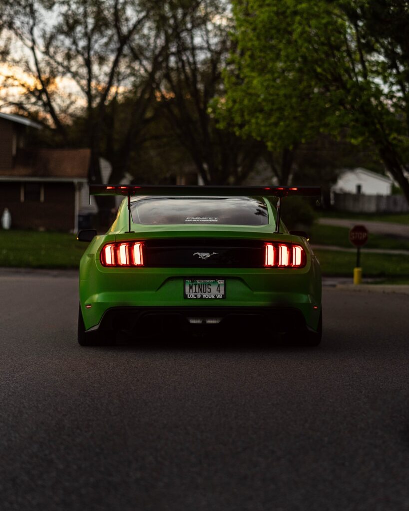 Rear View of Striking Green Ford Mustang in Suburban Setting Wallpaper