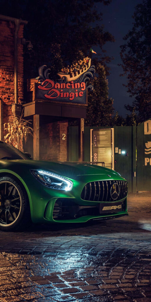 Green Mercedes AMG GT R parked under night streetlights showcasing aggressive grille and sleek design Wallpaper