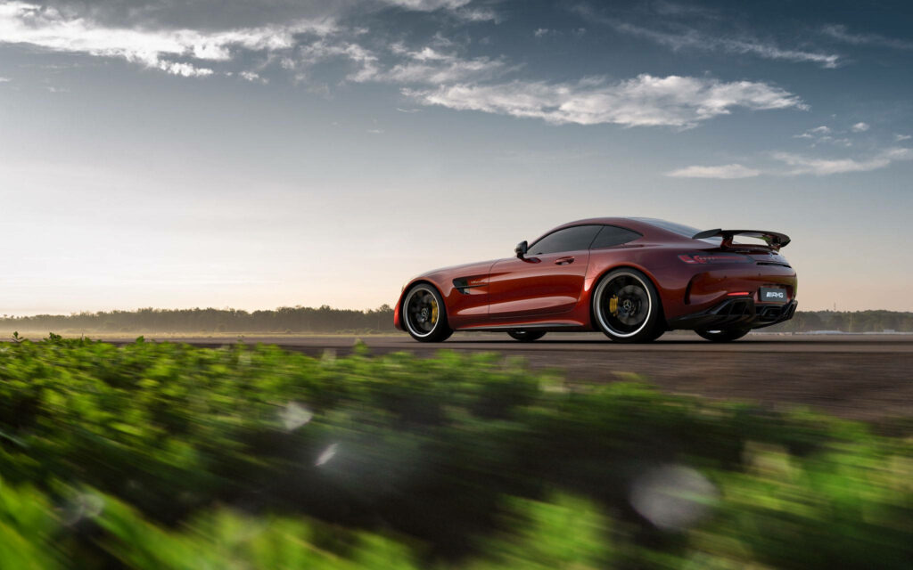 Jupiter Red Mercedes AMG GTR parked outdoors showcasing sleek design and scenic wallpaper backdrop