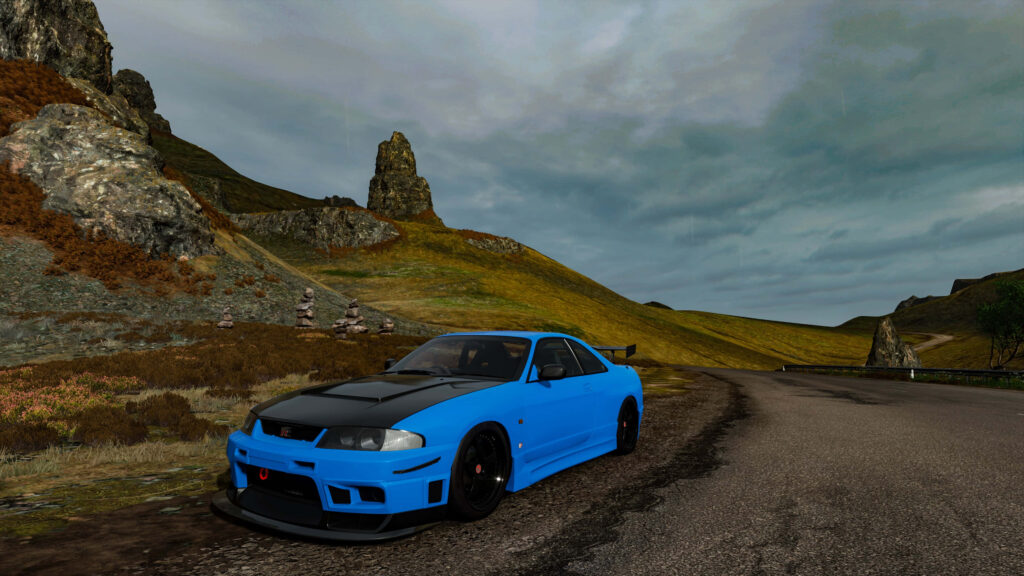 Light blue and black R33 GTR sports car on winding road with rugged hills and cloudy sky background Wallpaper