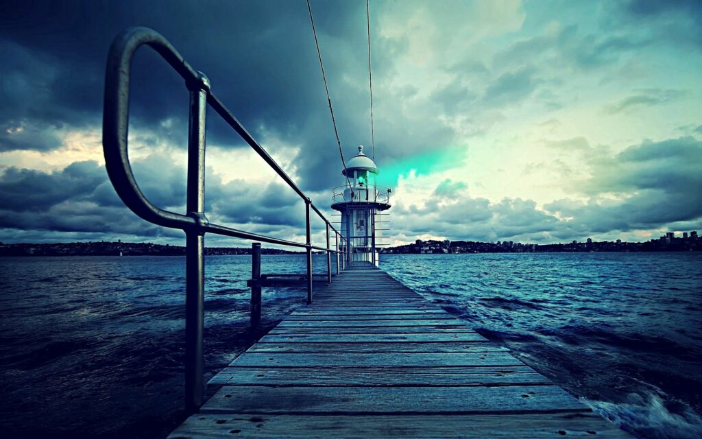 Moody Lighthouse Wallpaper: Pier View & Dramatic Sky Background