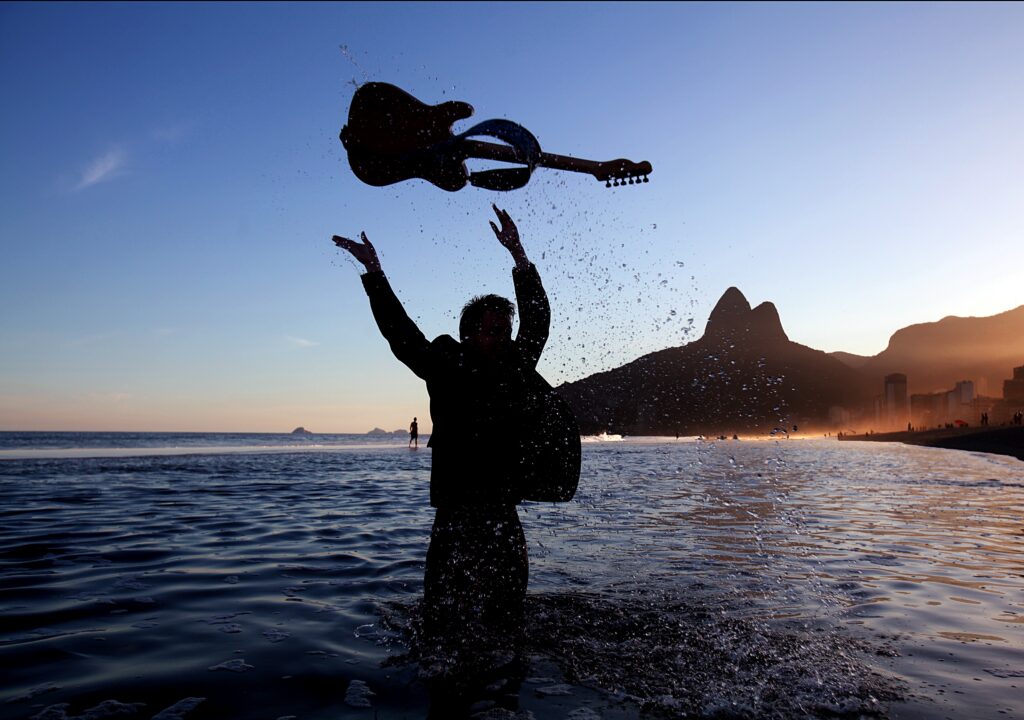 Musician in Shallow Sea Water: Striking Wallpaper Background