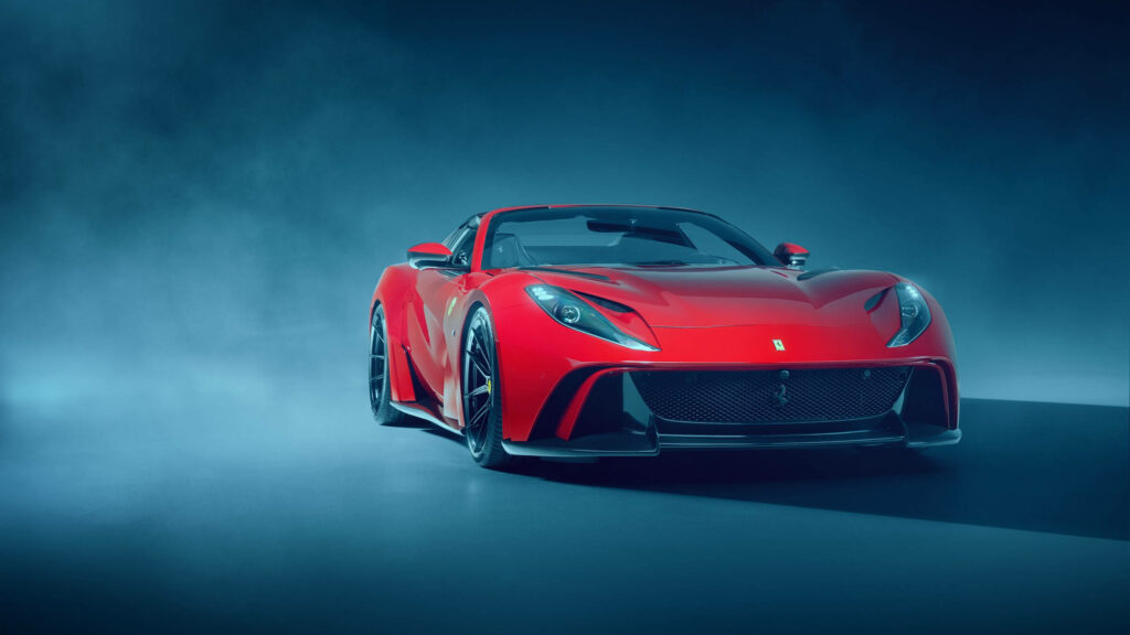 Red Ferrari 812 Superfast sports car with sleek design on dramatic blue background wallpaper