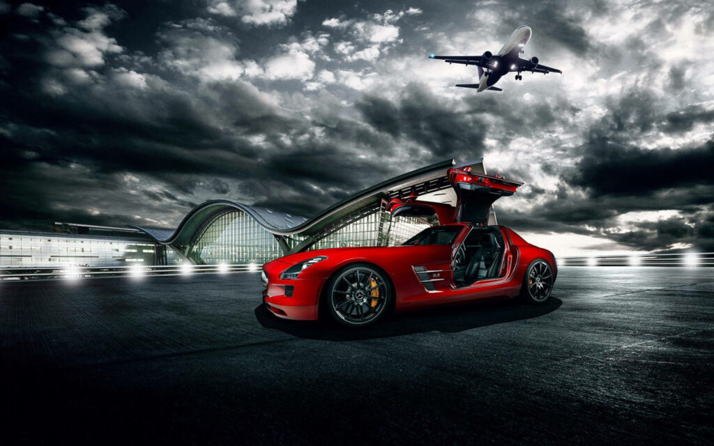 Red Mercedes Benz with gullwing doors open by modern airport terminal under moody sky aircraft Wallpaper