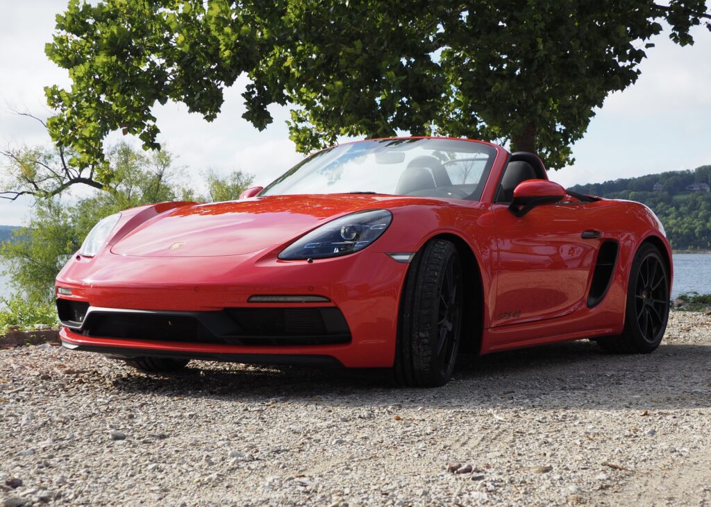 Red Porsche 718 Boxster: Sleek Design Against Scenic Background Wallpaper