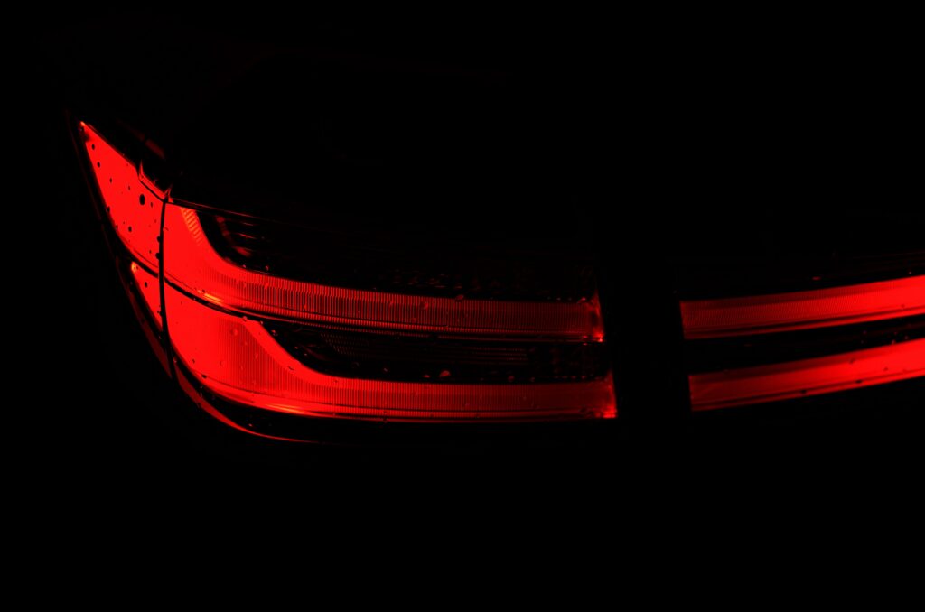 Glowing Red Taillight Wallpaper: Striking Contrast on Black Background