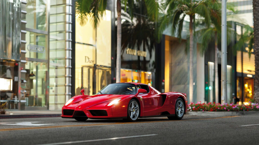 Dynamically Swift: A Captivating Red Ferrari Enzo Racing Towards the Horizon Wallpaper