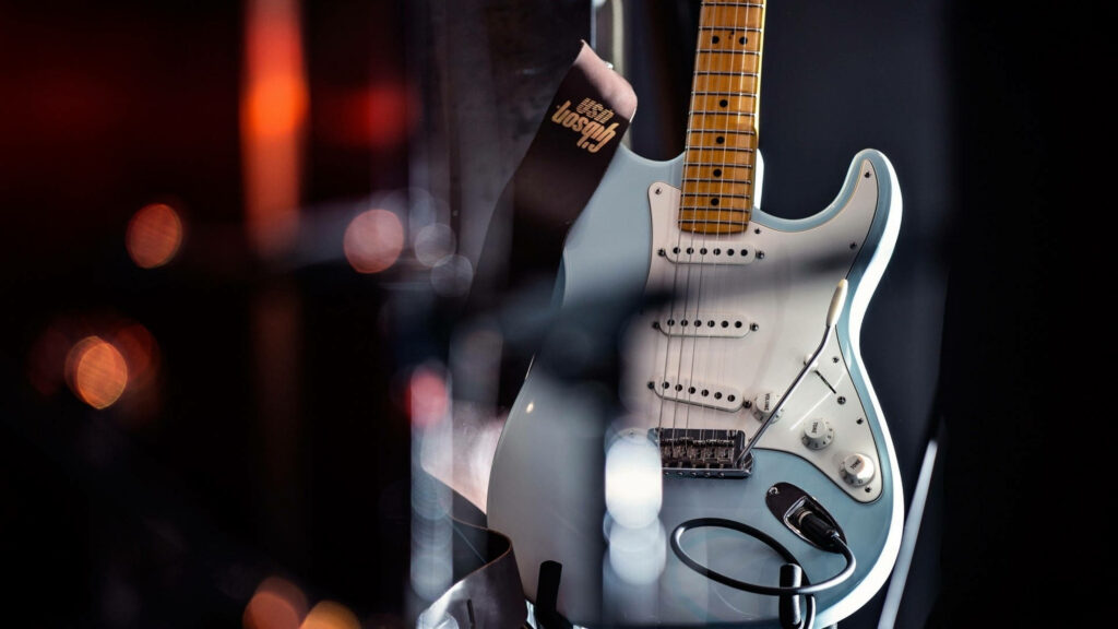 Striking Stage Presence: A Mesmerizing Light Blue Guitar Takes Center Stage Wallpaper
