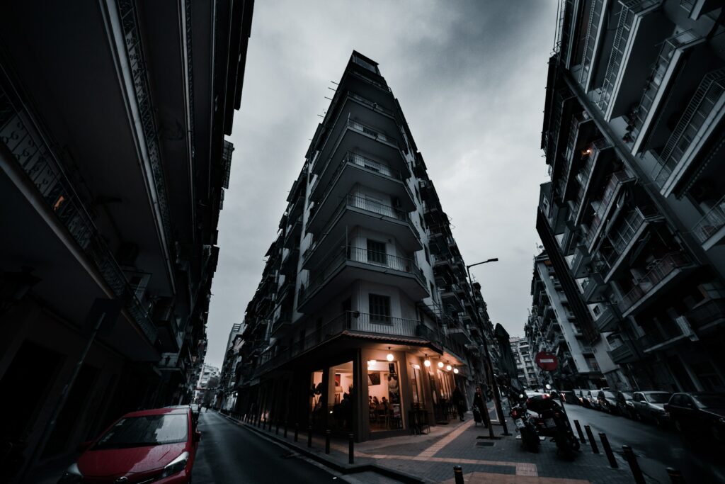 Triangular Building Facade Wallpaper - Urban Perspective Under Clouds