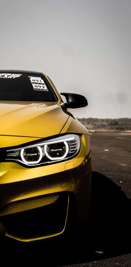 Yellow BMW car on open road sharp detailed sleek modern Android wallpaper background