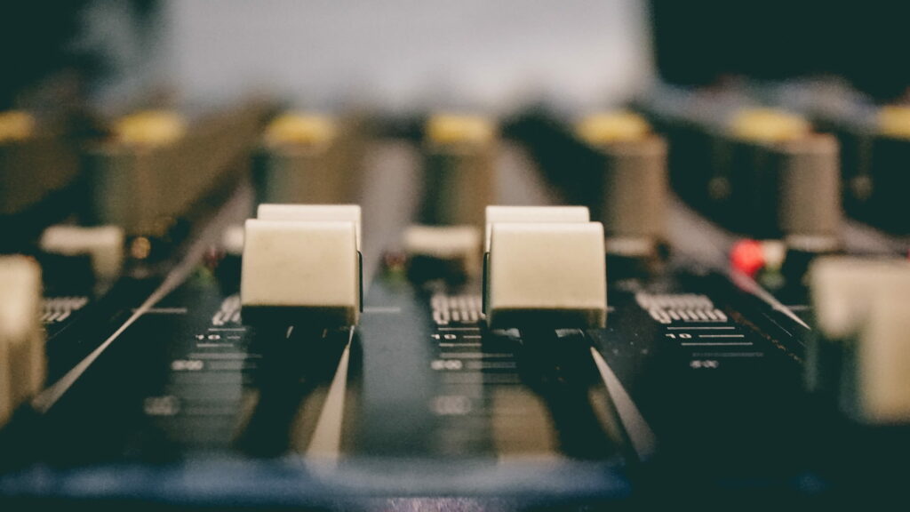 Mixing it Up: A Captivating Close-Up of Studio Equalizer Knobs on a Vibrant Wallpaper Background