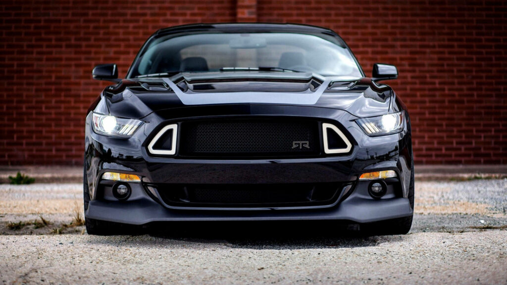 Aggressive black Mustang RTR front view 4K Ultra HD wallpaper with textured brick wall background