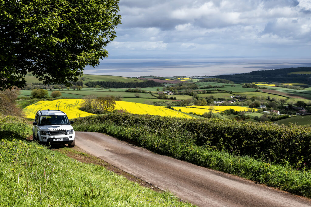 Scenic 6144x4096 Wallpaper: White Land Rover Amid Lush Greenery