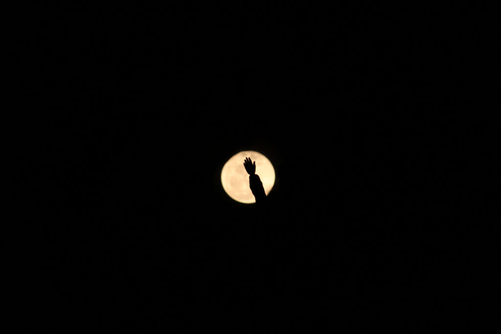 “Stunning AMOLED Wallpaper: Hand Silhouette & Vibrant Full Moon Background”