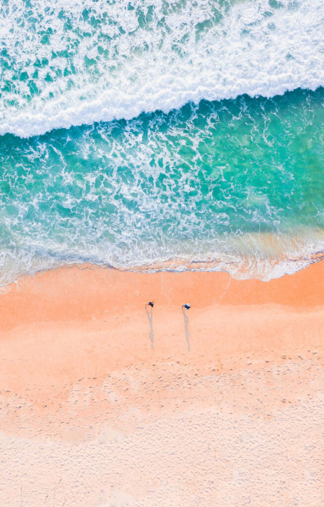 Vibrant Aerial Beach View: Turquoise Waves & Surfers Wallpaper