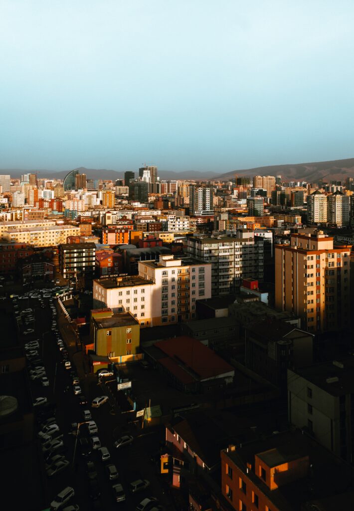 Warm Sunlit Cityscape Wallpaper: Aerial Urban Overview Background