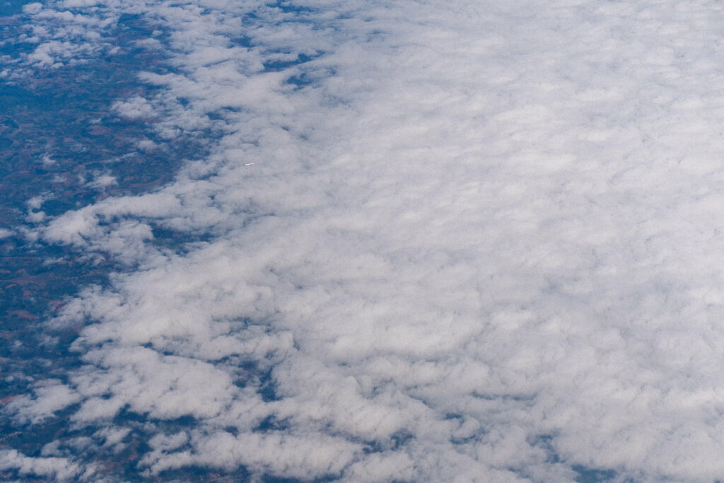 Serene Aerial View: White Clouds Against a Blue Sky Background Wallpaper