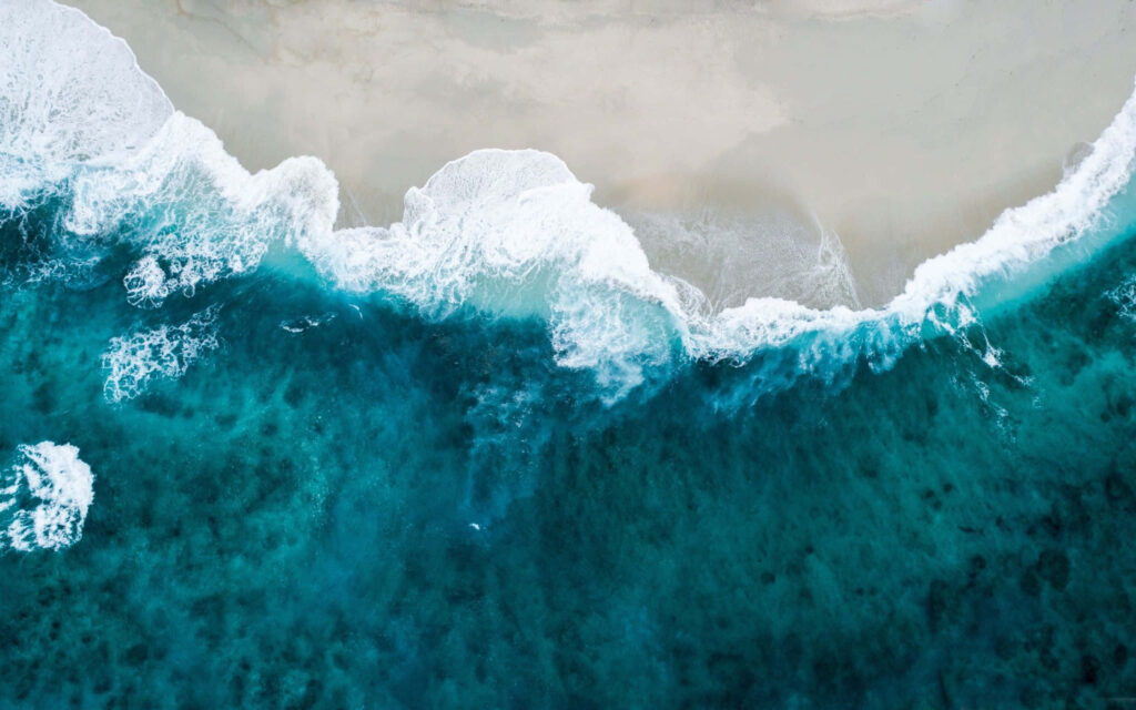 Stunning Coastal Wallpaper: Aerial Ocean Meets Sandy Shore Background