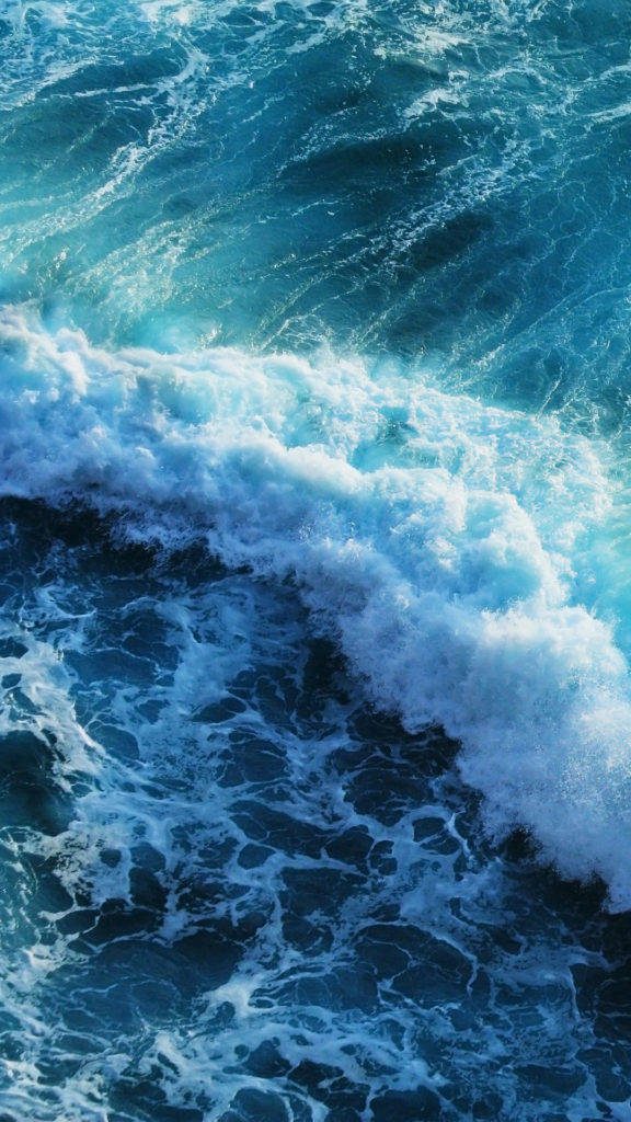 Aerial view of deep blue and turquoise ocean waves crashing with white sea foam background Wallpaper