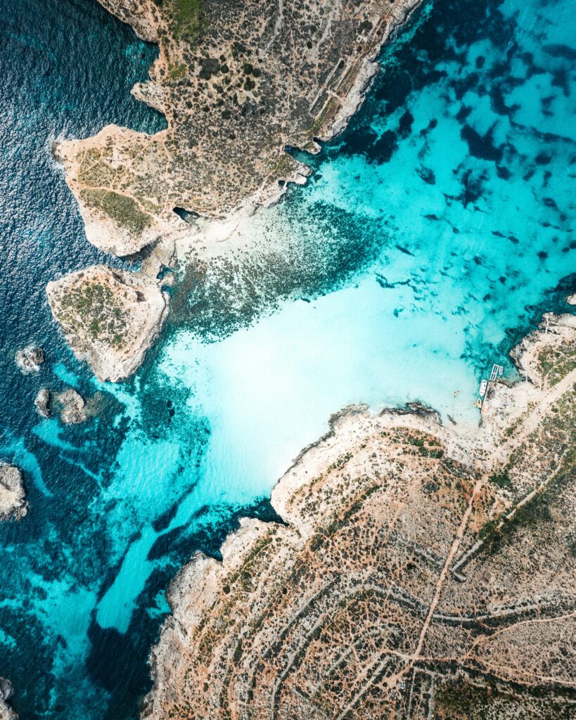 Aerial view of Malta turquoise waters rugged coastline narrow sea channel and lush islands wallpaper