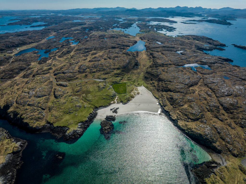 Aerial view of rugged islands with turquoise water rocky landforms and green patches coastline wallpaper