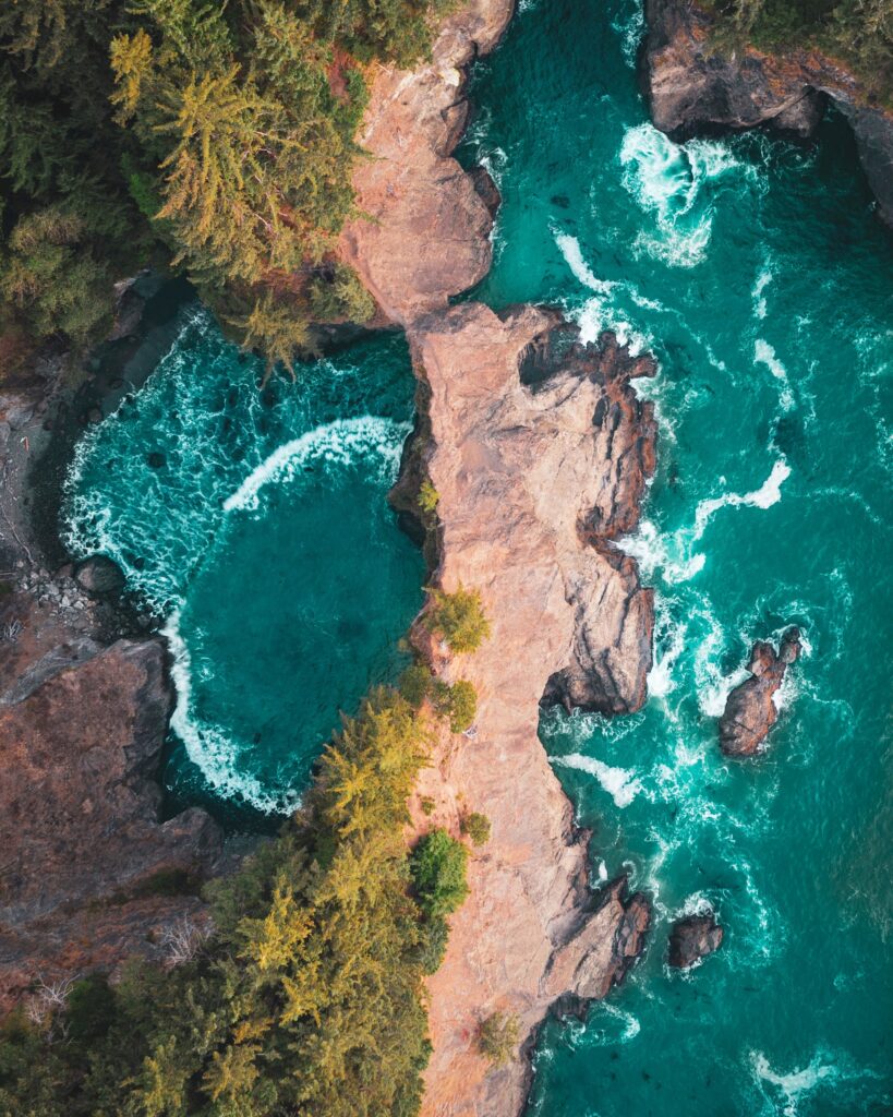 Aerial view of rugged rocks dividing turquoise lagoon surrounded by lush green trees wallpaper