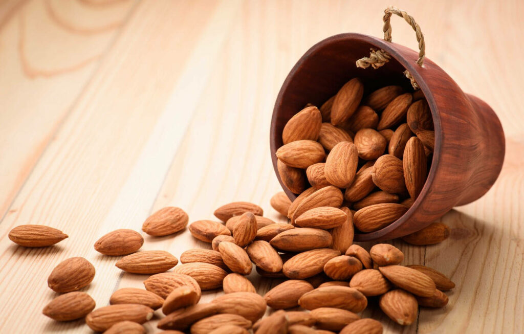 Rustic Almond Wallpaper: Raw Nuts on Wooden Surface for Natural Vibe