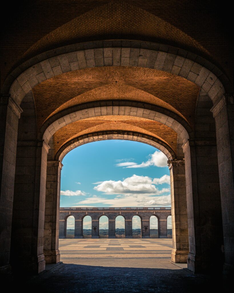 Stunning Stone Archway Wallpaper: Symmetry Against a Blue Sky