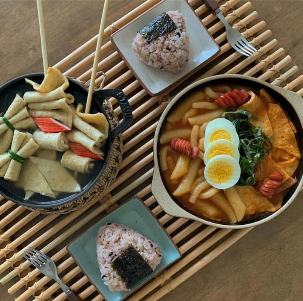 Stunning Asian Cuisine Table: Tteokbokki, Fish Cakes, and Nori Rice Wallpaper