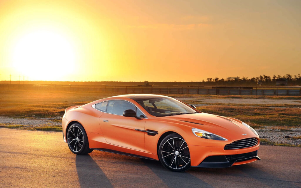 Sleek Aston Martin Vanquish Wallpaper with Golden Sunset Background