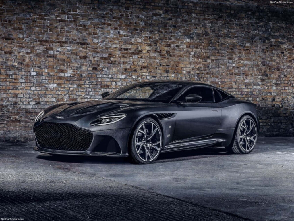 Elegant Aston Martin Wallpaper: Luxury Car Against Brick Backdrop