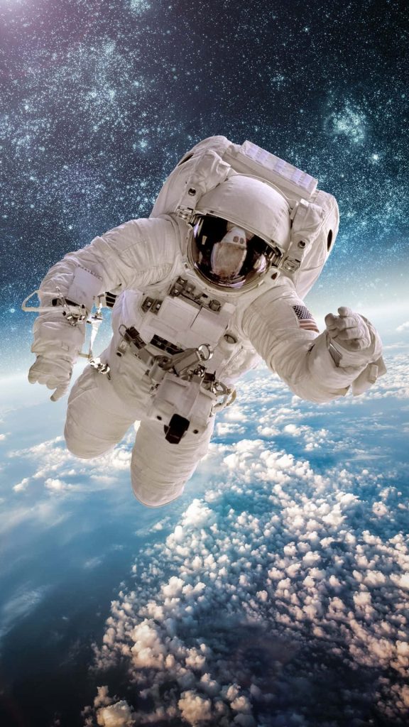 Astronaut floating above Earth with clouds and starfield in high-quality space wallpaper