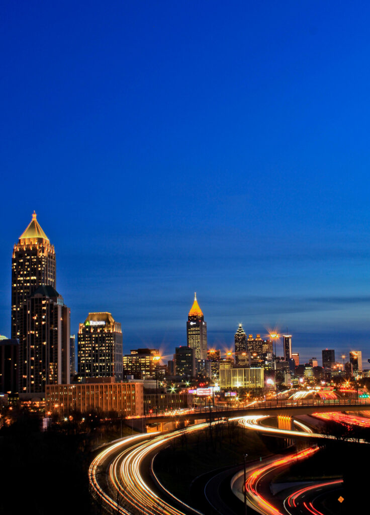 Evening Atlanta Skyline Wallpaper: Vibrant Light Trails on Deep Blue Sky