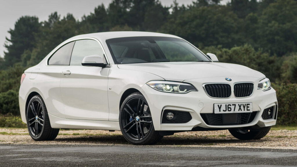 Sporty BMW 2 Series Coupe Wallpaper in Lush Natural Background