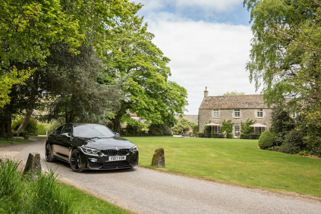 Luxurious BMW M4 showcasing elegance against charming rural backdrop Wallpaper