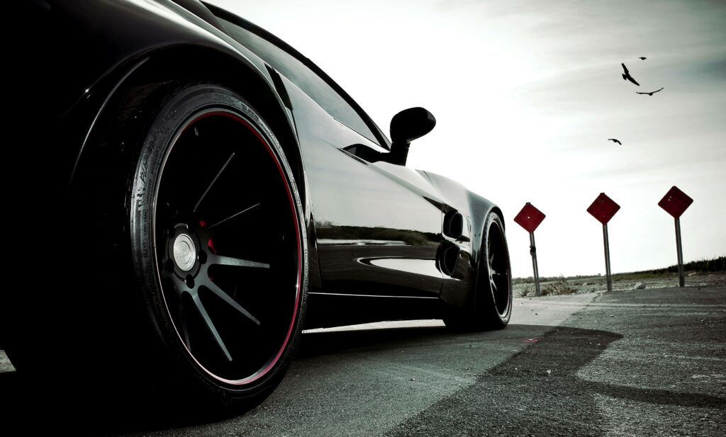Stunning Backdrop: A Captivating View of a Black Sports Car in Amazing Angle Photography Wallpaper