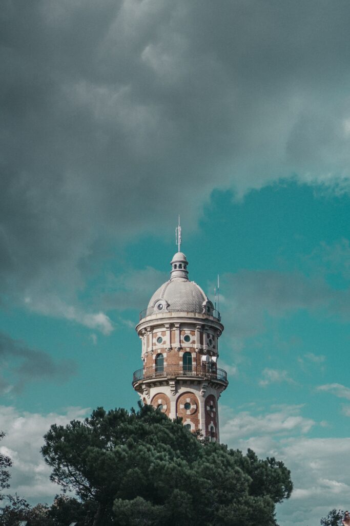 Stunning Barcelona Tower Wallpaper with Dramatic Sky & Greenery