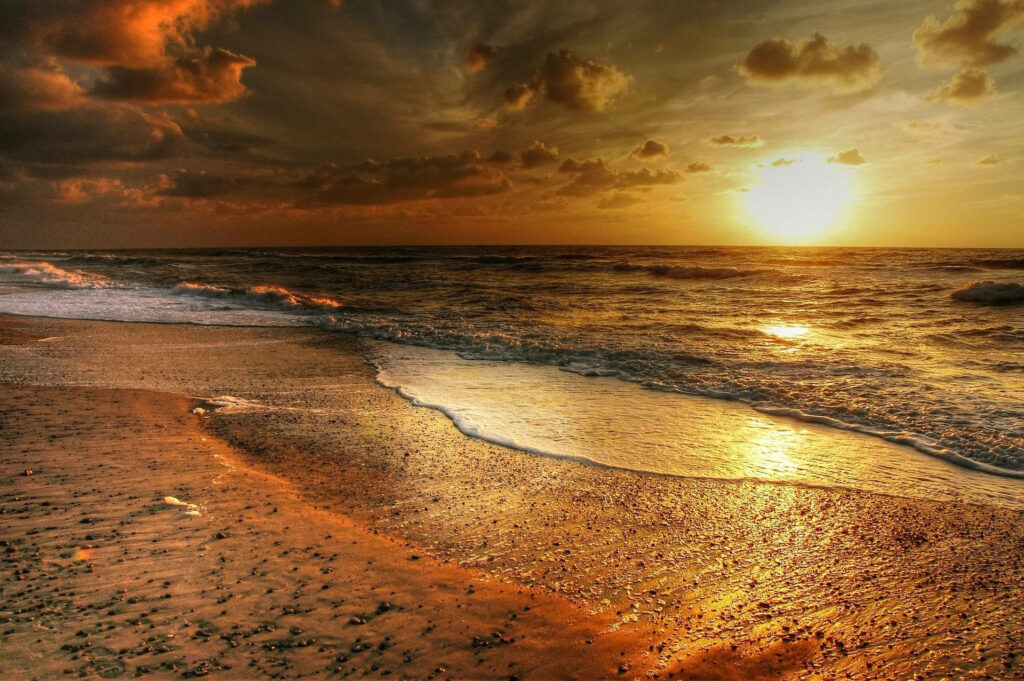 Stunning Sunset Beach Wallpaper: Warm Glow & Dramatic Skies