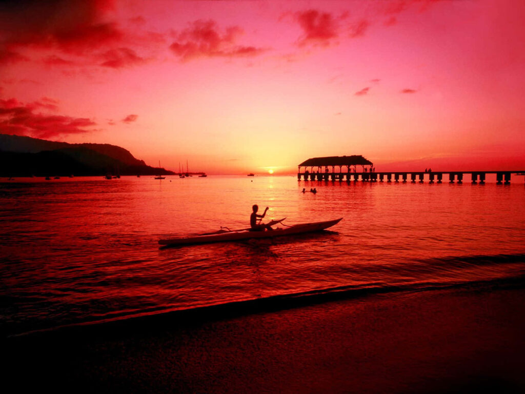 Tranquil Beach Sunset Wallpaper: Pink and Orange Sky with Kayaker