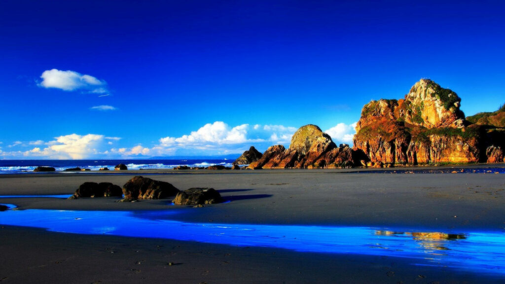 Tranquil Beach Wallpaper: Vibrant Sky & Picturesque Rocks
