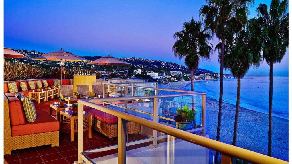 Serene Beachside Balcony Sunset Wallpaper with Cozy Seating