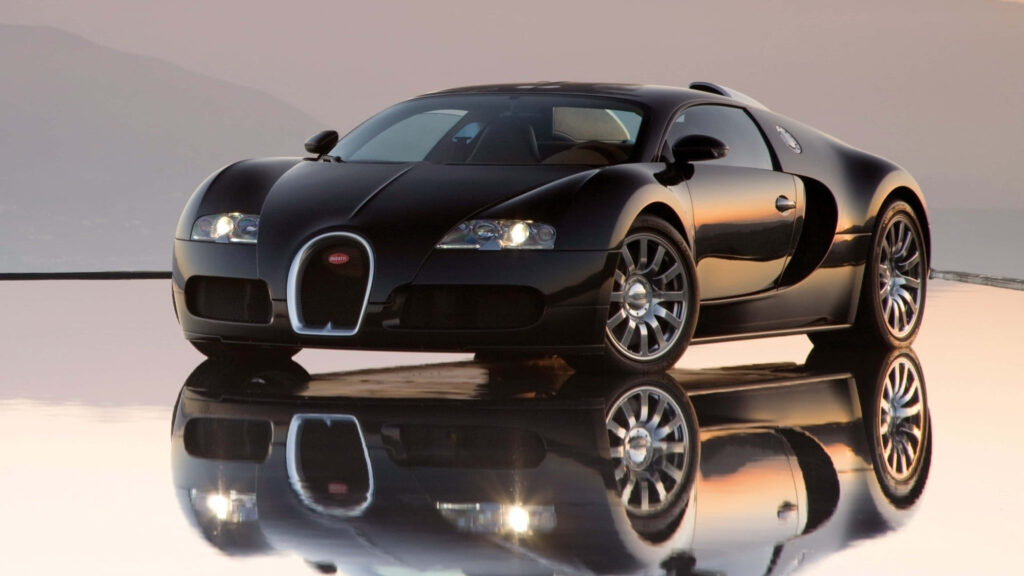 Black Bugatti supercar flawlessly reflected on smooth surface under soft evening sky wallpaper