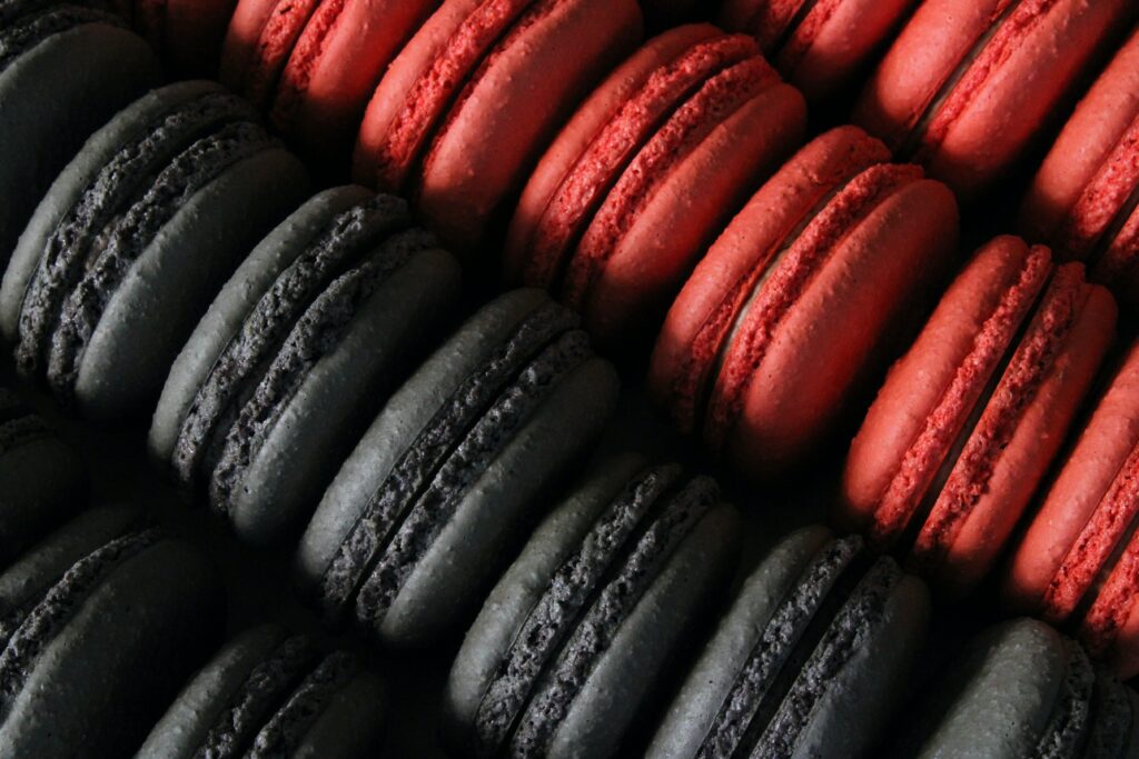 Stunning Black and Red Macarons Close-Up: Textured Shells & Fillings Wallpaper