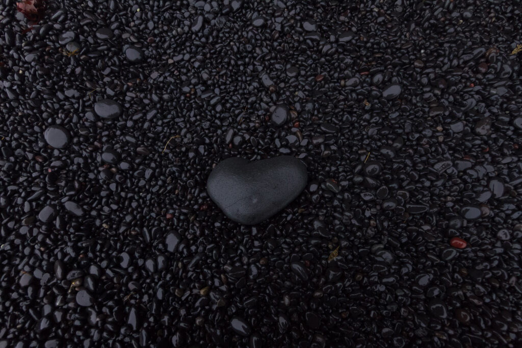 Textured Black Stones Wallpaper with Heart-Shaped Pebble Accent