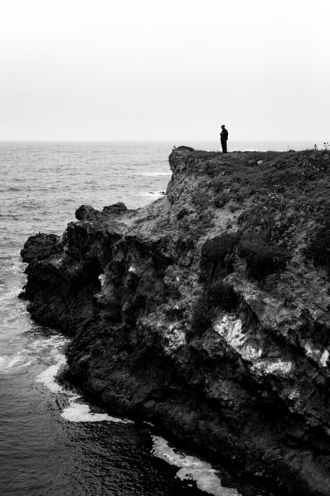 Stunning Black & White Cliff Wallpaper: Ocean Waves & Solitary Figure