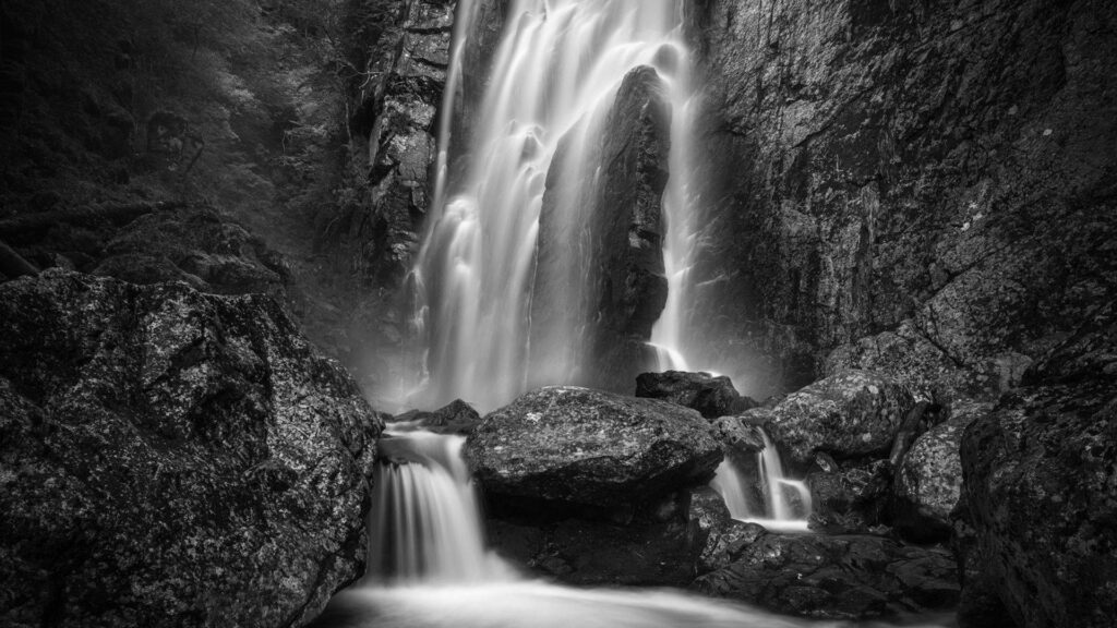 Stunning Monochrome Wallpaper: Serene Waterfall Over Rugged Rocks