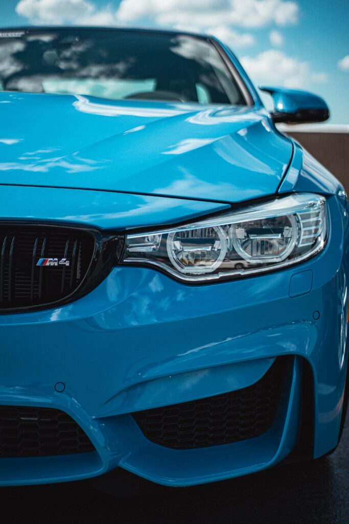 Stunning Blue BMW M4: Sleek Design Against Clear Sky Background Wallpaper