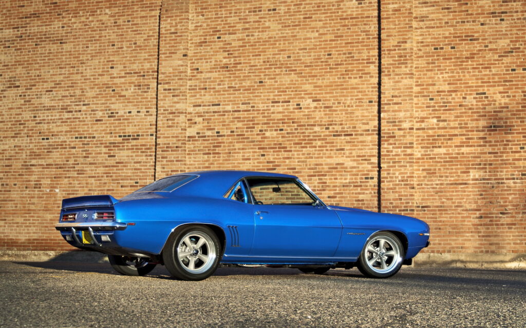 Blue Chevrolet Camaro Wallpaper: Sleek Muscle Car on Brick Wall