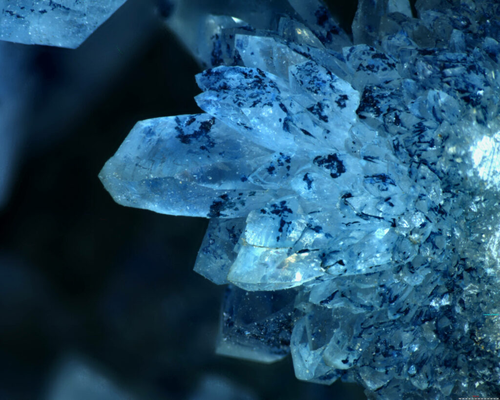 Close-up of blue crystal minerals with intricate geometric patterns and shimmering transparency Wallpaper