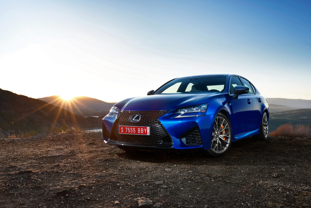 Stunning Blue Lexus GS: Sleek Design Against Scenic Sunset Background Wallpaper